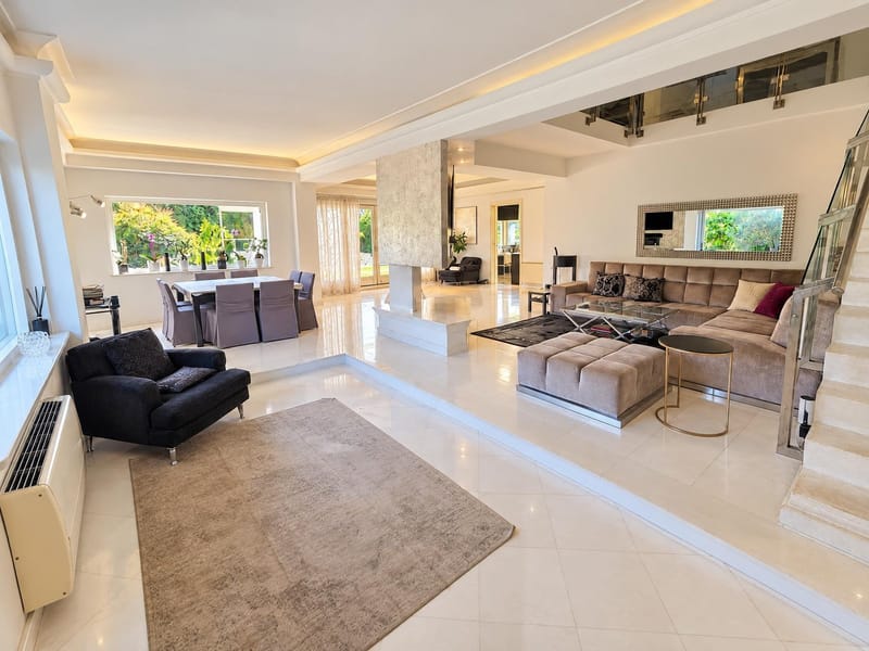 After: the same living room, brighter and warmer, without the boxes, shoes and toys; sofas, table and staircase unchanged