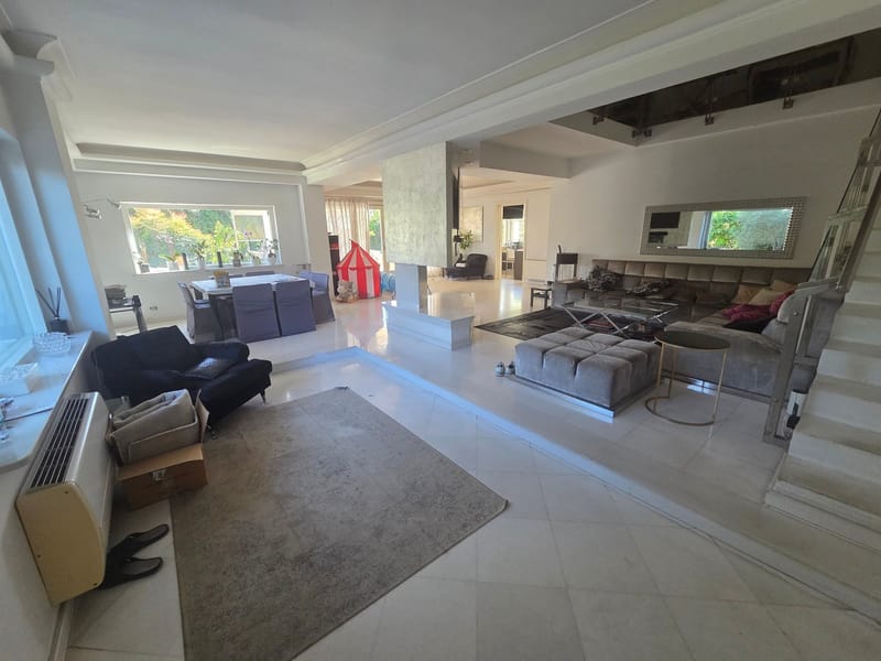 Before: large living room with a staircase, dull colors, boxes, shoes and a play tent on the floor