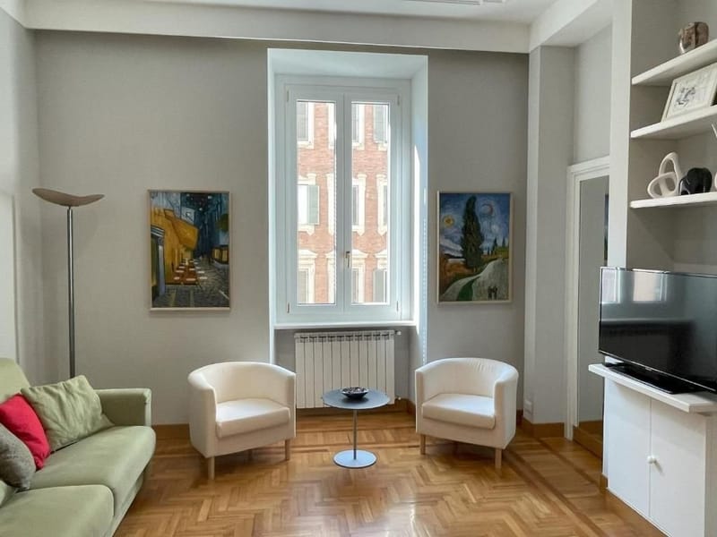 Before: living room with two white armchairs in front of the window and the floor lamp off, in flat gray light